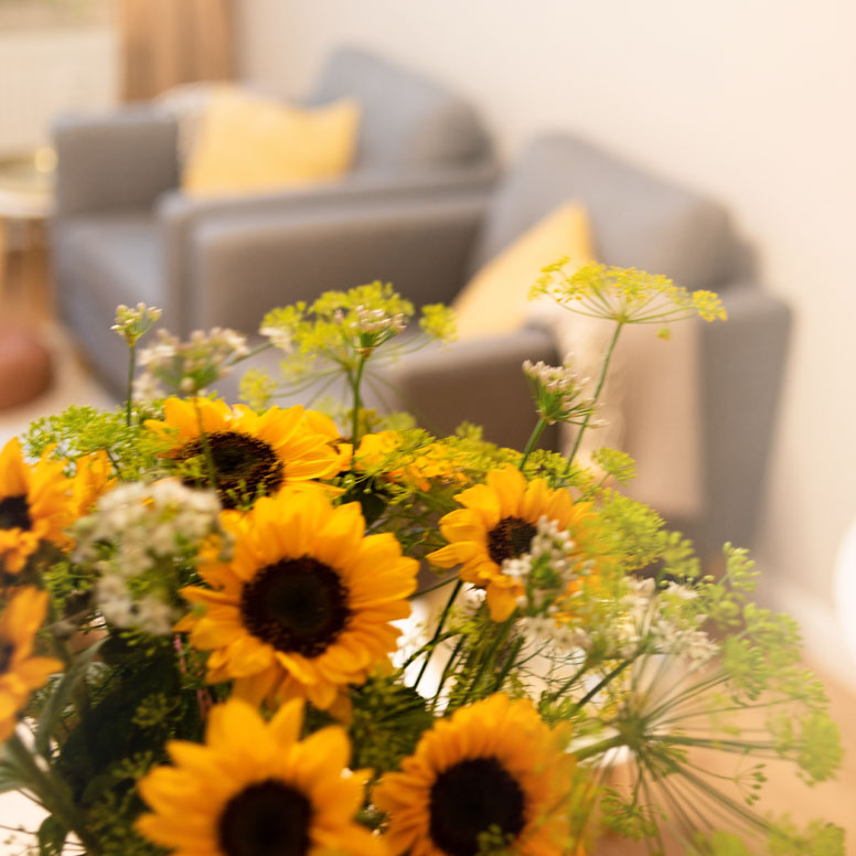 Sonnenblumenstrauß mit Sesseln im Hintergrund